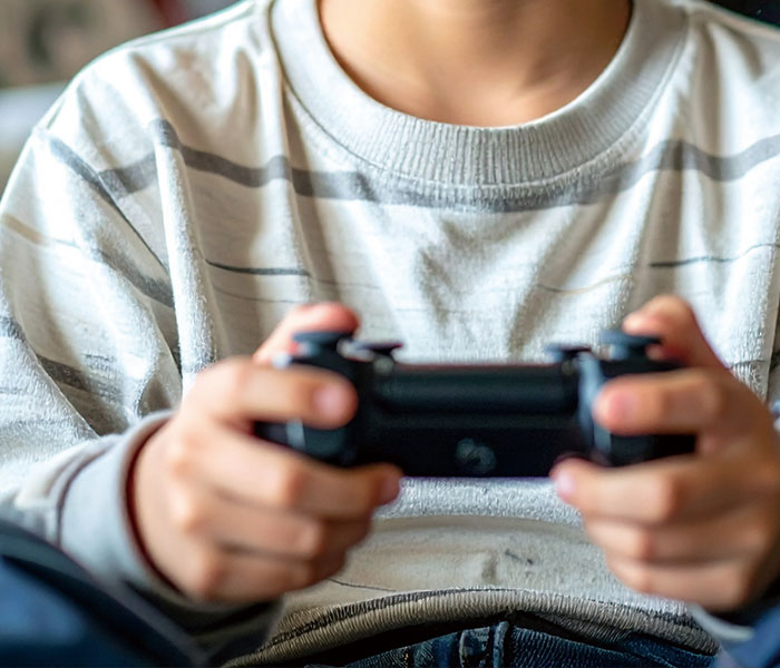 ゲーム機を手に遊んでいる少年